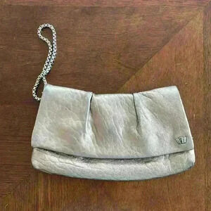Beautiful Henri Bendel bronze wristlet with purple interior